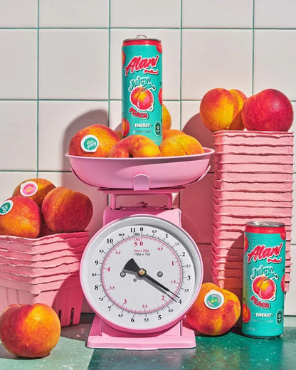 Alani Nu Juicy Peach Energy Drink lifestyle photo — sugar-free 12 pack